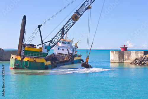 Ship for dredging the silted seabed in the Italian harbour of Marina di Pisa - Italy photo