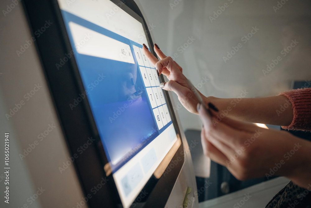 Obraz premium Touch screen, modern technology. Woman is using banking terminal indoors