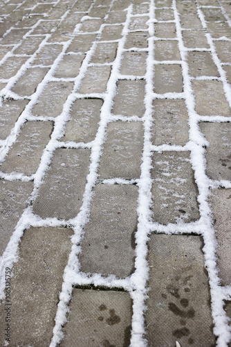 Frosted patio, ice and snow in the joints of the pavers