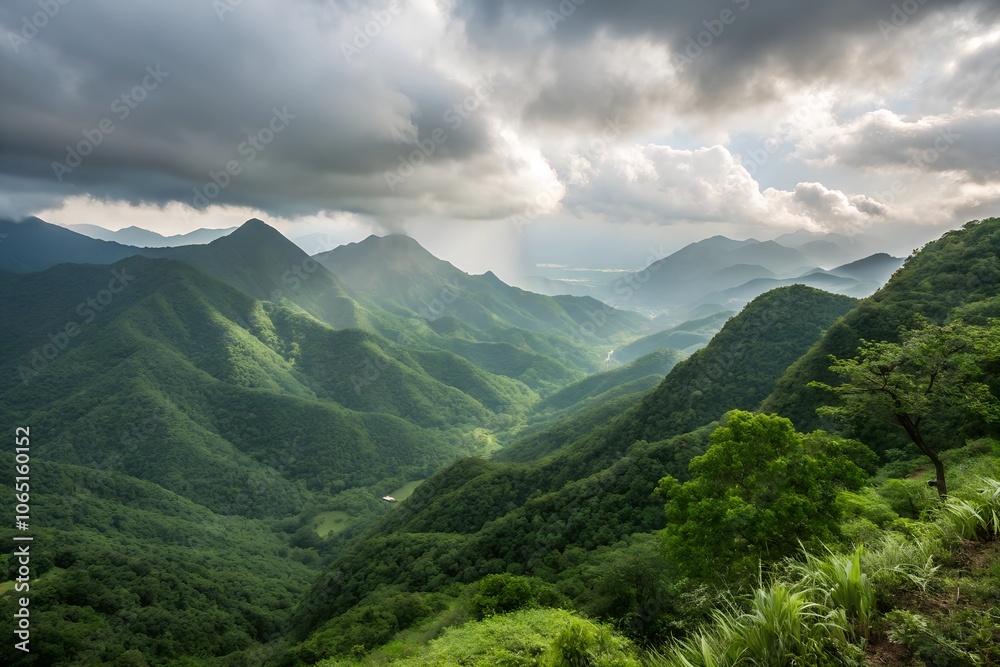 Obraz premium Scenic view of lush green mountains under a cloudy sky.