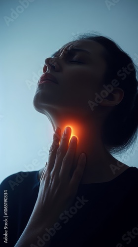 Woman in pain touching her neck due to a sore throat against a dark blue background, capturing the discomfort of throat inflammation from illnesses like laryngitis or tonsillitis