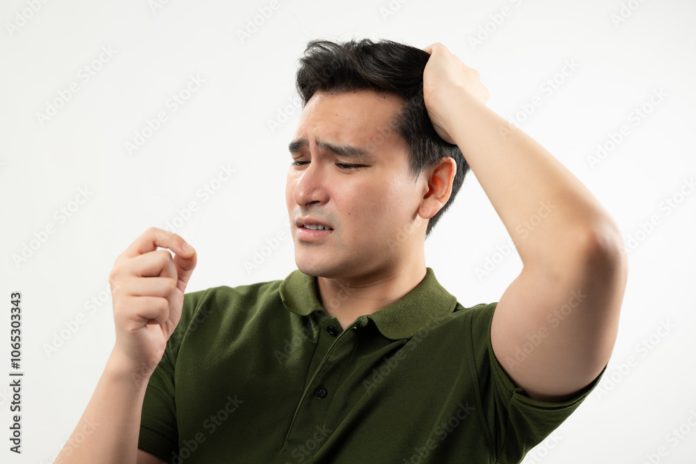 Concerned man inspecting a hair strand, highlighting hair loss or thinning hair issues Concerned man inspecting a hair strand, highlighting hair loss or thinning hair issues