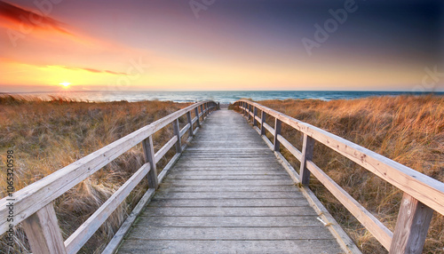 Fototapeta Naklejka Na Ścianę i Meble -  amazing nature on Baltic Sea beach, wooden boardwalk threw the sandy dunes at sunset