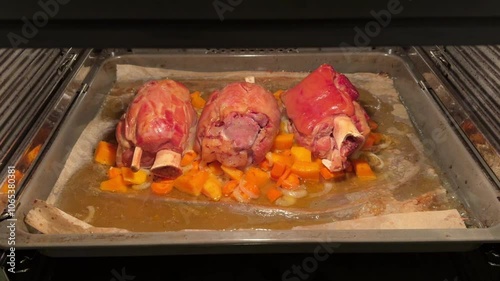 Pork knuckle baked on a baking sheet in the oven. Delicious restaurant or homemade dish for a festive lunch or dinner. Fatty high-calorie male food. Oven-cooked meat