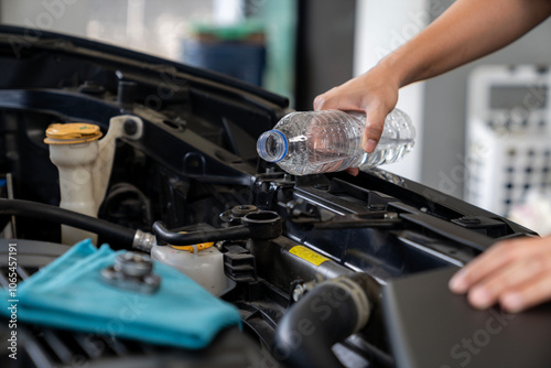 Close-up of woman's hand opening windshield wiper tank to check fluid level, car maintenance photo