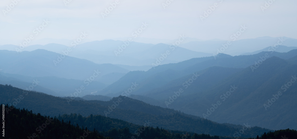 Obraz premium Rocky deep gorge with sharp sheer crags silhouettes against blue sky. Horizontal image.