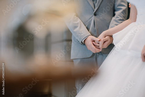 Close-up of the bride and groom holding hands