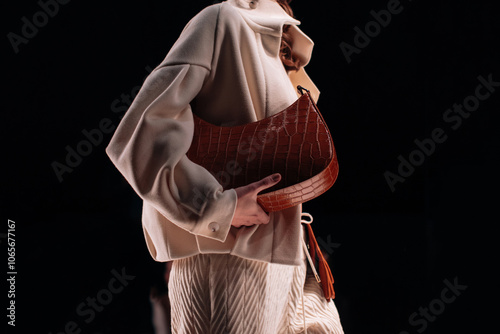 Elegant fashion details of warm jacket, skirt and brown leather handbag, women's fashion cloth concept on black background photo