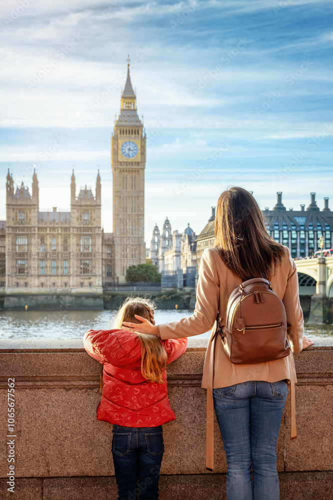 A mother and her daughter enjoy the view of the Big Ben tower in London, England, during a city sightseeing trip