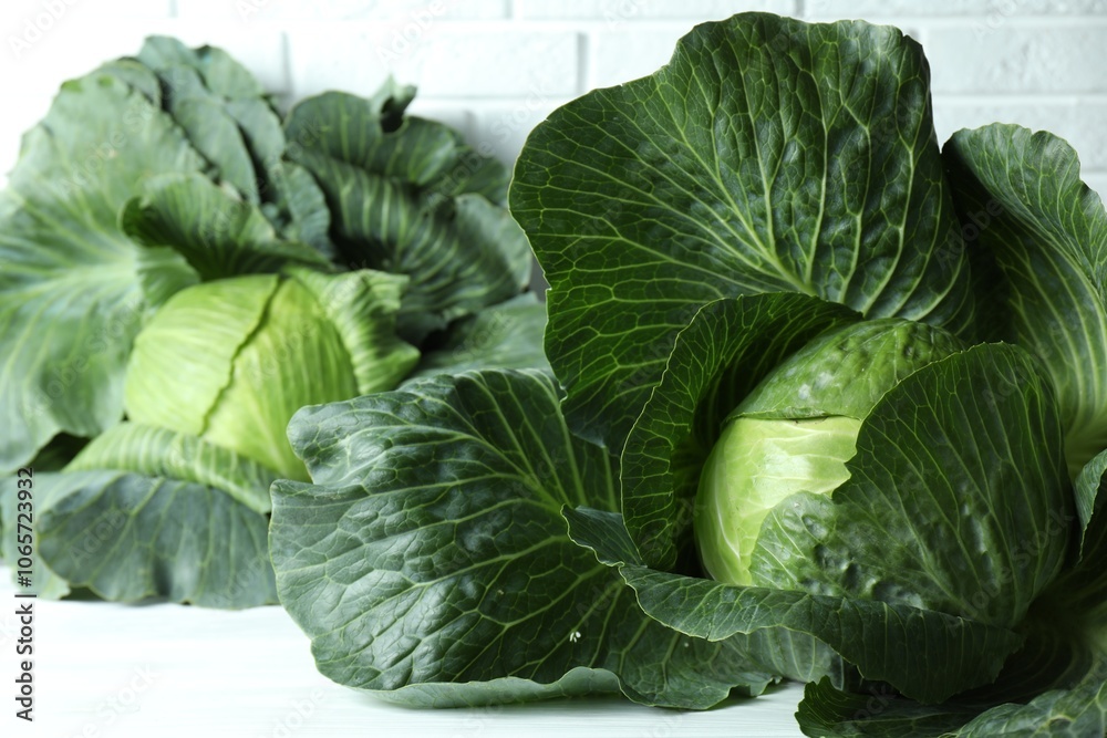 Obraz premium Ripe heads of cabbages on white table, closeup