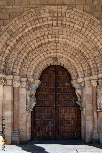 Romanesque style entrance with a splayed arch and capitals decorated with sculptures in the Basilica of Saints Vicente Sabina and Cristeta, in Avila. Spain photo