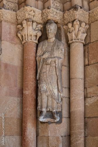 sculpted capitals and sculpture of a saint at the entrance  in the Basilica of Saints Vicente Sabina and Cristeta, in Avila. Spain