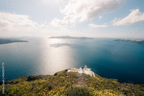 Skaros Rock at Imerovigli village with volcanic island Nea Kameni in background, Santorini, Greece photo