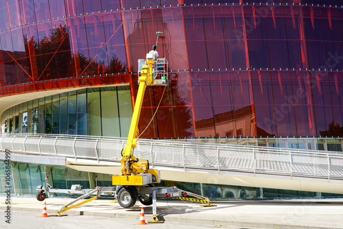 Schilderij op canvas Glass facade cleaning works of a modern building using a modern telescopic boom