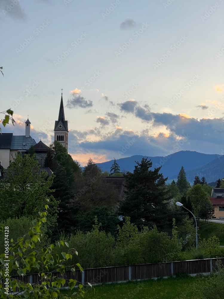Fototapeta premium Charming village church and serene landscape at sunset in Austria