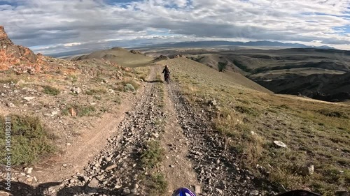 POV Rider Driving Enduro Dirt Motorbike on Gravel Trail in mountain road, offroad traveling together with friend motorcyclist