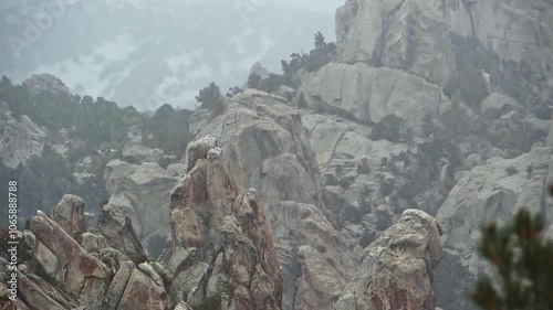 Telephoto pan up on rock formations in a snowstorm in Castle Rocks State Park, Idaho