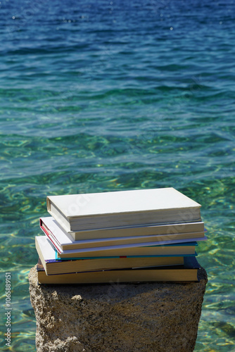 Stacked books in the nature by the sea, conceptual photo of learning and education