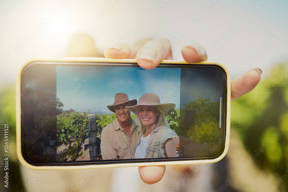 Naklejka premium Phone screen, hand and selfie of happy couple at vineyard for vacation, holiday or travel closeup. Senior man, woman and picture at winery farm with mobile for memory or photo on date by grape field