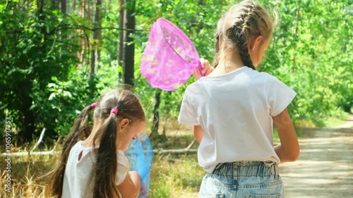 Children girls walking in the forest with device for catching butterflies footage 4k video slow motion