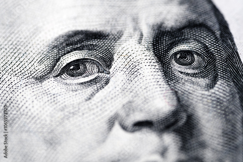 Close-up macro photograph with soft focus of Benjamin Franklin’s eyes on a U.S. one-hundred-dollar bill, detailed textures and intricate patterns of fine lines and dots. Design of the currency.