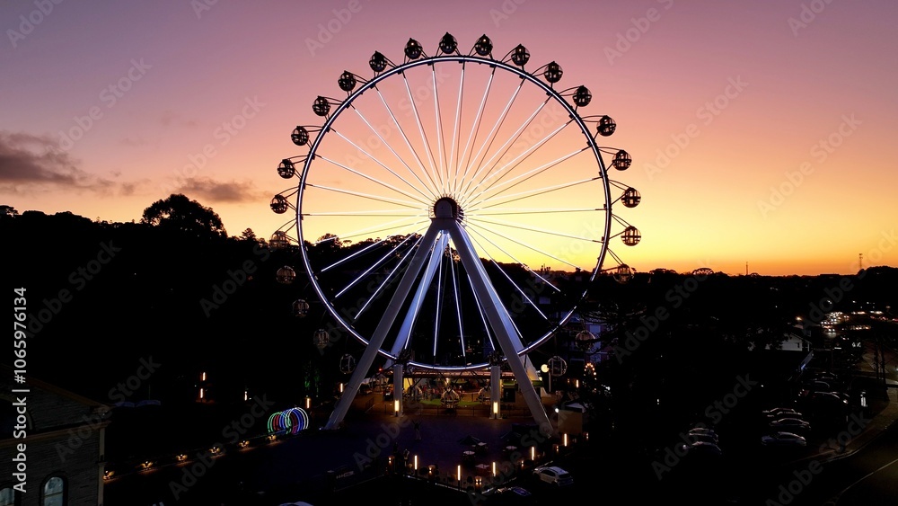 Illuminated Ferris Wheel At Canela In Rio Grande Do Sul Brazil. Colorful Ferris Wheel. Illuminated City. Sunset Landscape. Illuminated Ferris Wheel At Canela In Rio Grande Do Sul Brazil. Illuminated Ferris Wheel At Canela In Rio Grande Do Sul Brazil. Colorful Ferris Wheel. Illuminated City. Sunset Landscape. Illuminated Ferris Wheel At Canela In Rio Grande Do Sul Brazil.