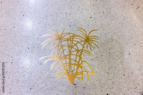 Golden palm tree design embedded in terrazzo floor at Miami International Airport. photo