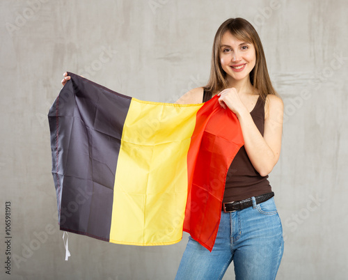 Young pretty woman posing cheerfully with flag of belgium photo