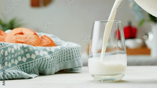 Pouring kefir yogurt into glass cup close-up. Glass with kefir or milk, lactic acid product dairy products concept. Drinking fresh lactose free in morning. photo