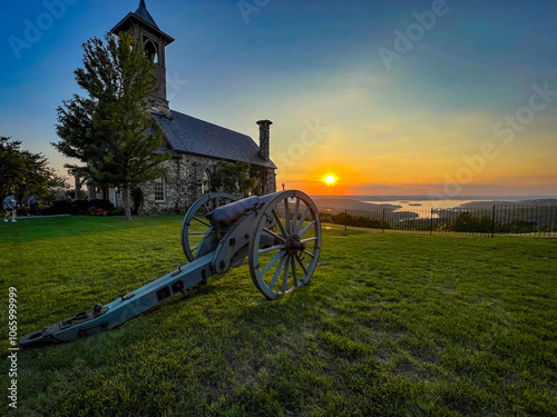 Mountain top chapel with antique canon in sunset photo