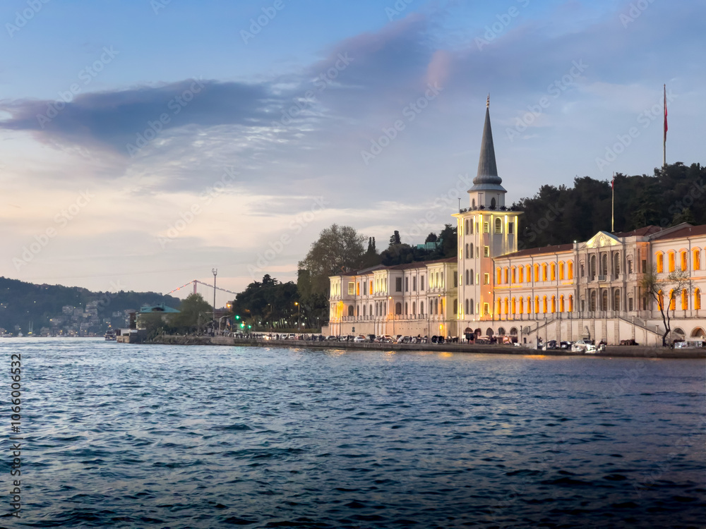 Obraz premium A large building with a tall spire sits on the shore of the Bosphorus in Istanbul, Turkey