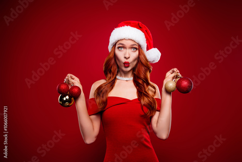 Photo of amazed girl in santa claus headwear hold christmas tree toys feel impressed over red color background photo