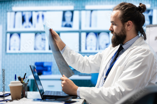 Licensed physician working on finding the right diagnostic with x ray scans results, examining bones radiography to detect illness. Medic analyzing healthcare records in hospital cabinet. photo