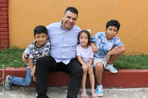 Single Dad with two brown latino sons and daughter spend time together and have fun to celebrate Father's Day in poverty