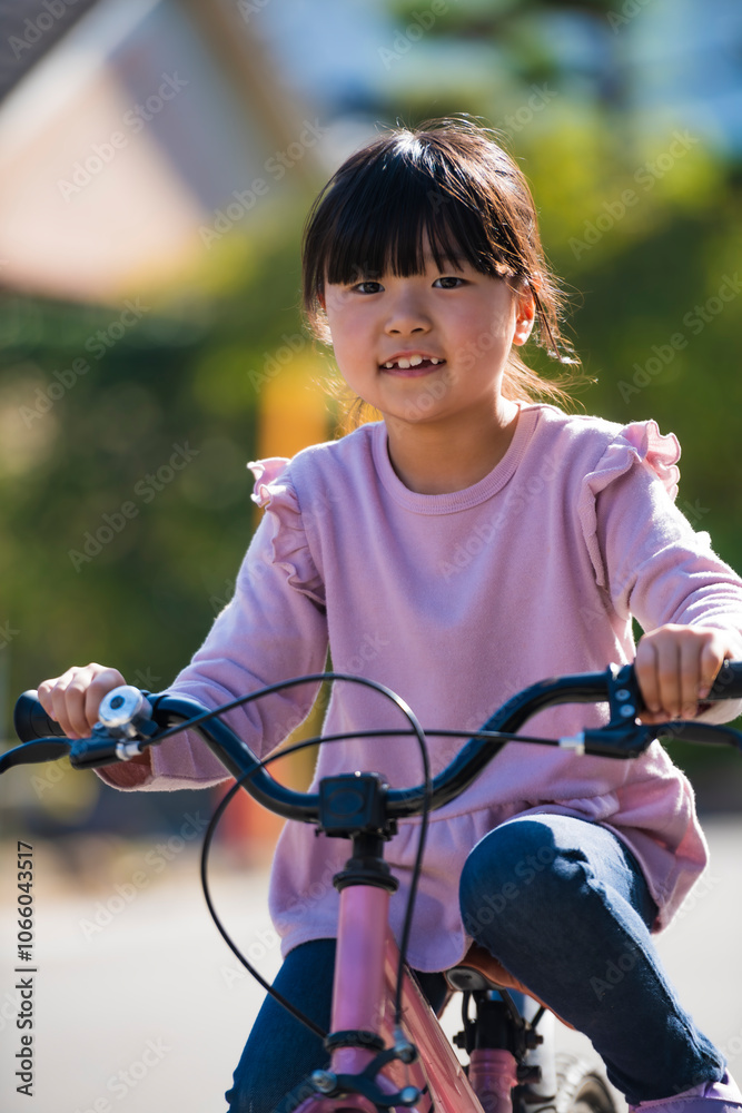 Obraz premium 自転車の練習に挑戦する小学生の女の子