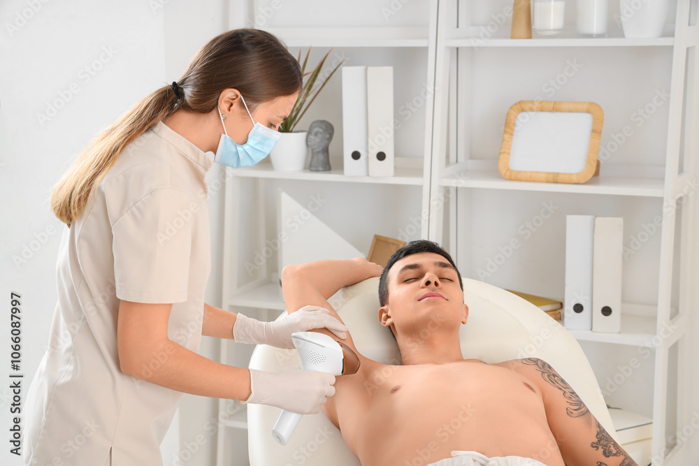 Cosmetologist using photoepilator for removal of hair from man's body in beauty salon Cosmetologist using photoepilator for removal of hair from man's body in beauty salon