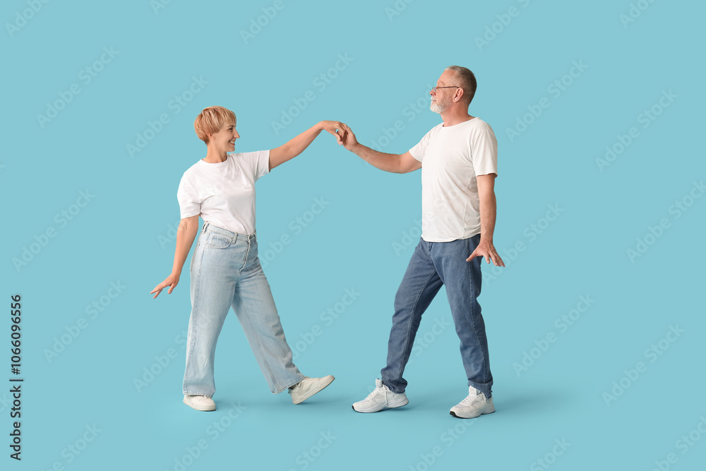 Naklejka premium Mature couple dancing on blue background