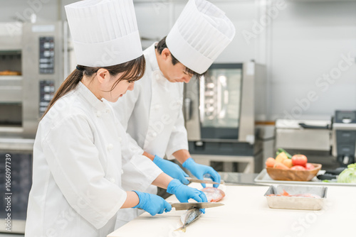 魚を調理するコックコート姿の男女スタッフ（料理人・生鮮市場・食品加工）
