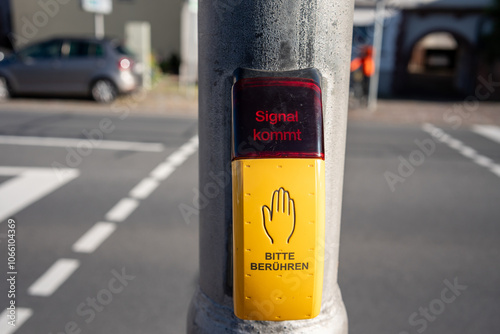 Ein Anforderungstaster an einer Fußgängerampel vermeldet dass das Signal für die Straßenquerung kommt