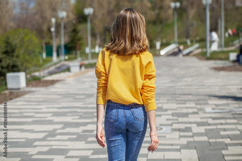 Back view, portrait of a young beautiful woman in blue jeans Back view, portrait of a young beautiful woman in blue jeans