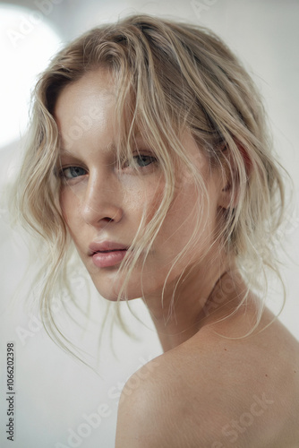 Ashy Blonde Waves: A soft and natural close-up shot of a face, has loose, ashy blonde waves that frame her face effortlessly photo