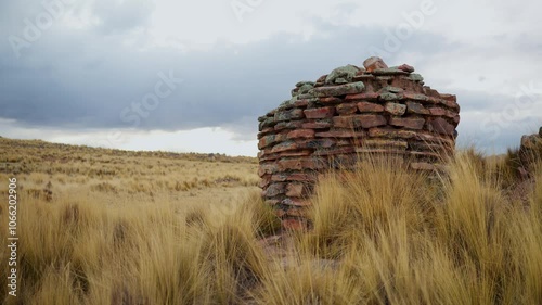 Inca chullpas in the Andes mountain range at sunset with a cloudy sky and surrounded by vegetation photo