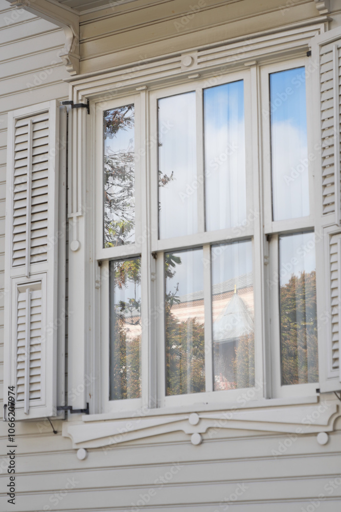 A Stunning Elegant White Window Featuring Shutters with a Beautiful Reflection Nearby A Stunning Elegant White Window Featuring Shutters with a Beautiful Reflection Nearby