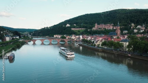 Cruise boat sailing on the Neckar river near famous arch bridge in Heidelberg photo