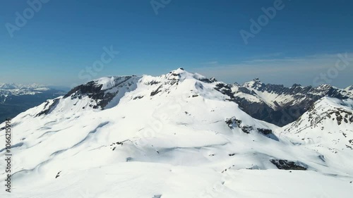 Grand Massif area within sight of Mont Blanc, France, aerial view. Snowy winter in French Alps, ski resort Flaine. Drone forward, ascending. Clear sky. Winter landscape.