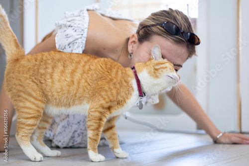 Cat owner is kissing and hugging her ginger cat with love and care after rescuing him from the pet shelter for sitter boarding service and life long companion partner concept