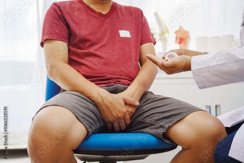 A man consults a doctor in a hospital for a male urinary tract infection. The doctor advises on symptoms like frequent urination, pain, and possible causes, including infections and prostate issues photo