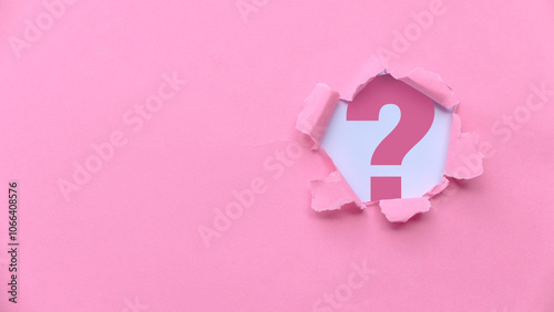 Pink Torn Paper Revealing the question mark symbol  photo