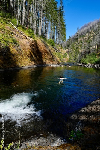 Hiker swimming in the eagle creek pool looking into the canyon. Pacific crest trail, oregon.