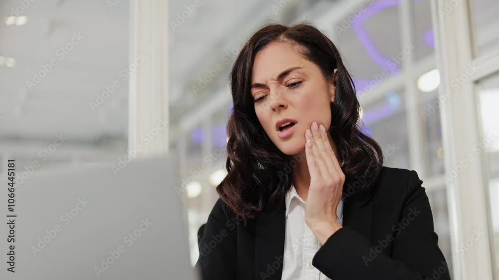 Businesswoman experiences a sudden toothache while working on her ...
